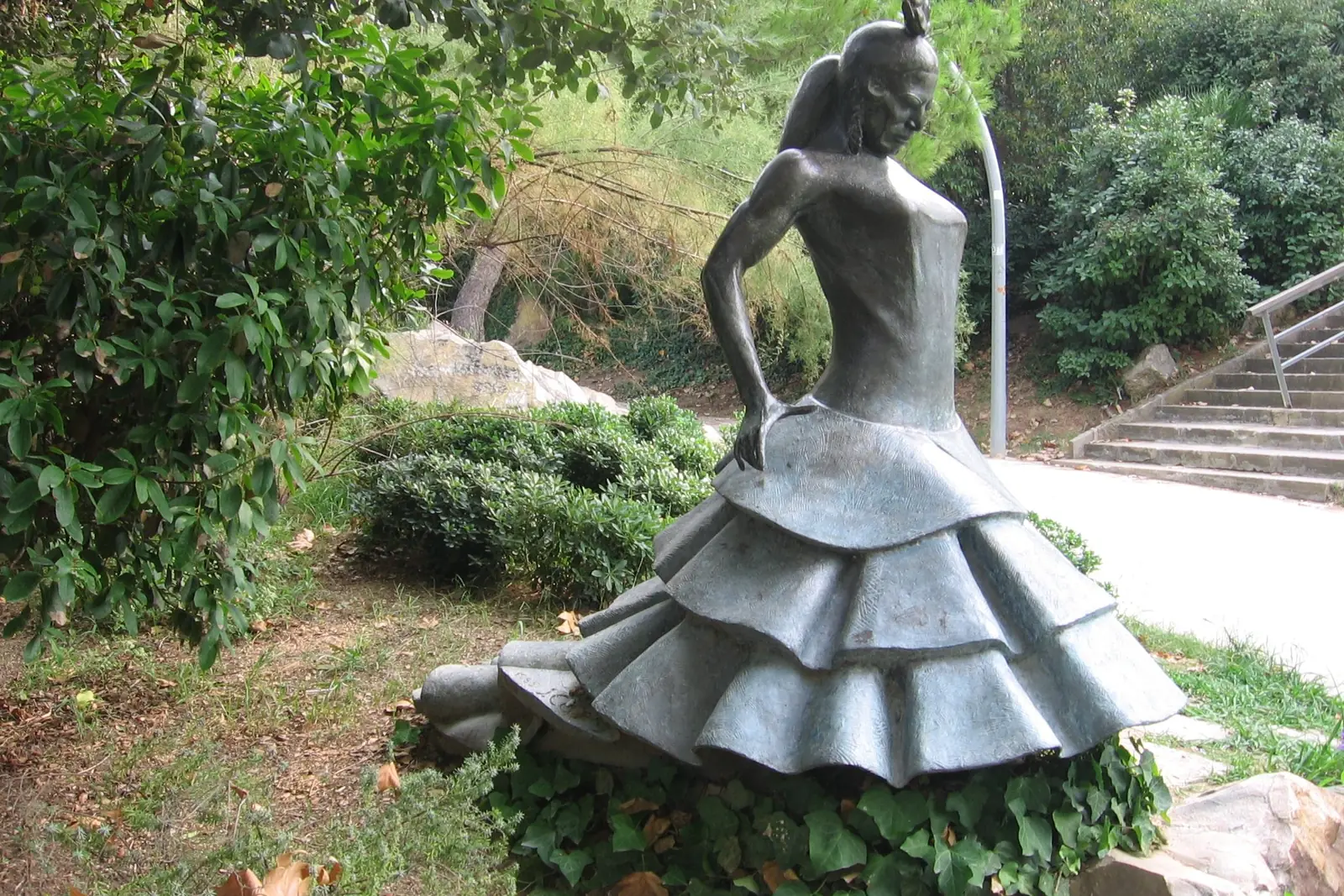 A bronze statue of a flamenco dancer in a ruffled dress, in a garden on Montjuïc, dedicated to Carmen Amaya